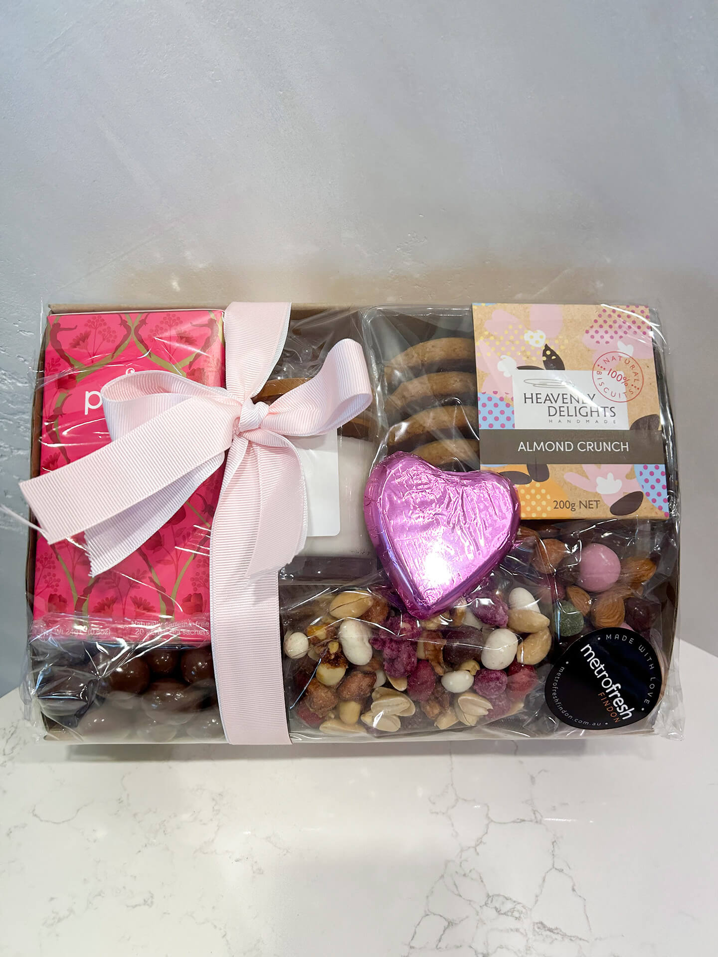 A gorgeous hamper of biscuits, tea, nuts and chocolate, and a small candle. The perfect gift to spoil someone today