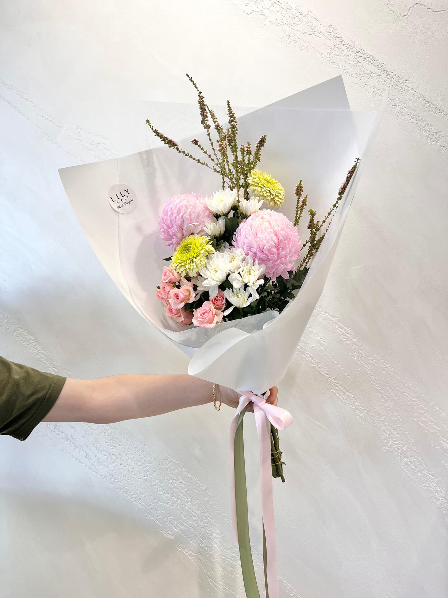 MIxed seasonal blooms in a wrapped bouquet. 