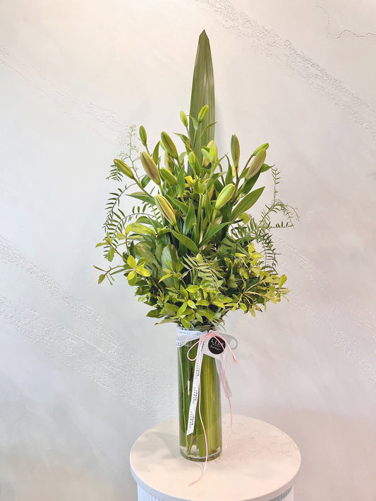 The Elegant Tiger Lily is a stunning combination of tall tiger lilies and lush green foliage, beautifully arranged in a clear glass vase finished with ribbon. 